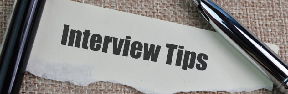 a paper with the words interview tips over a burlap background with a pen