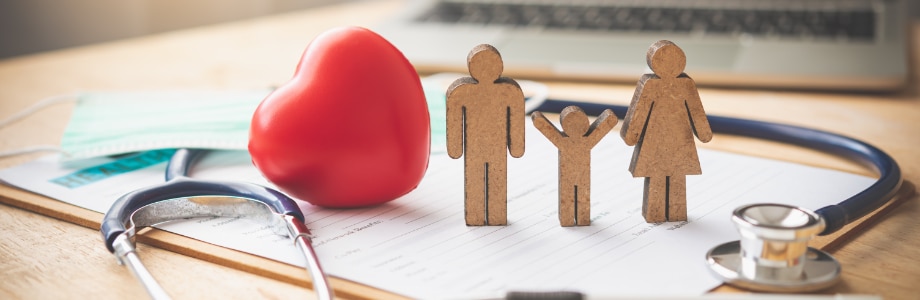 wooden family on a desk with a heart and stethoscope 