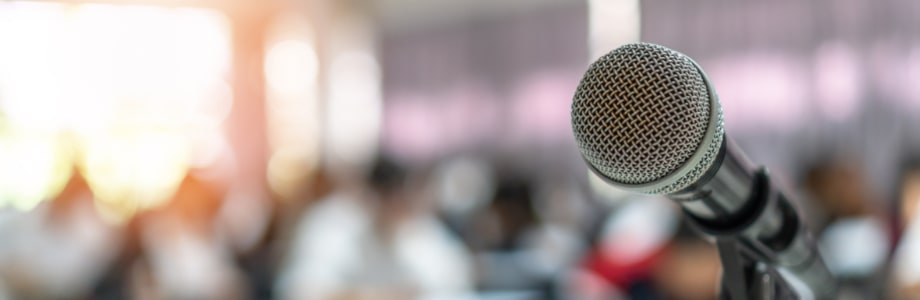 microphone on a stand in a classroom with out of focus students at desks