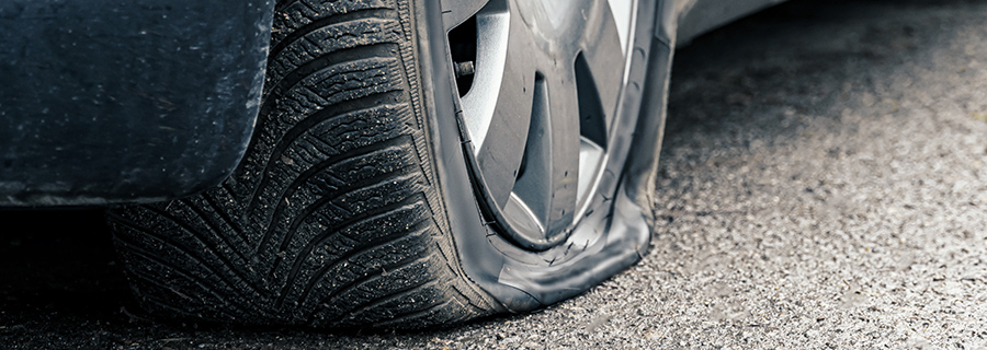 a close up of a flat car tire on the pavement