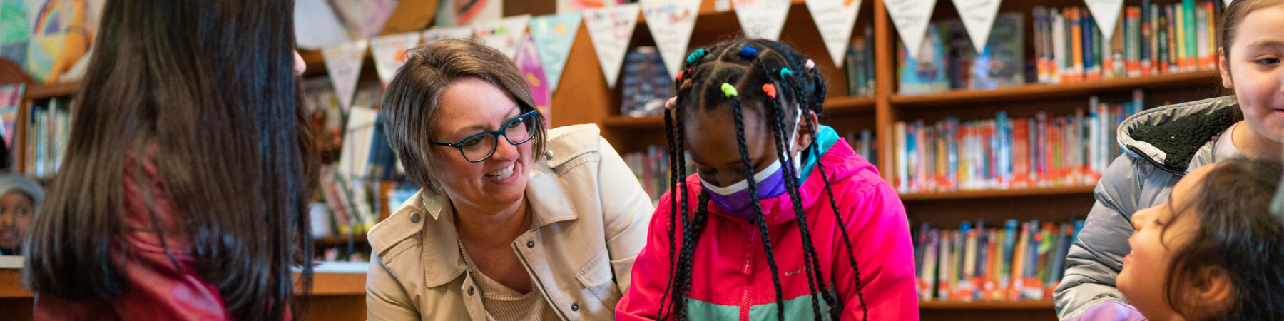 Principal and diverse students at a table.