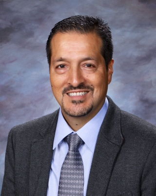 a photo of a man in a suit with blue shirt and tie